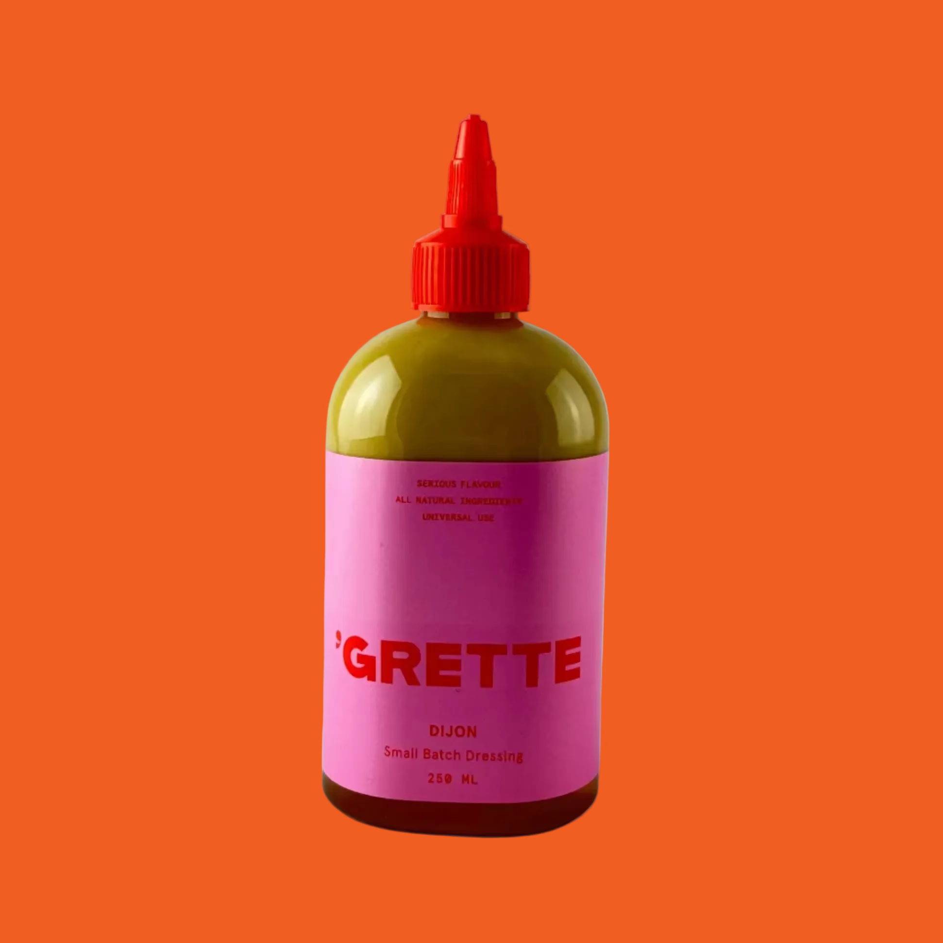 'Grette small batch dijon dressing in a pink and red bottle on a orange background