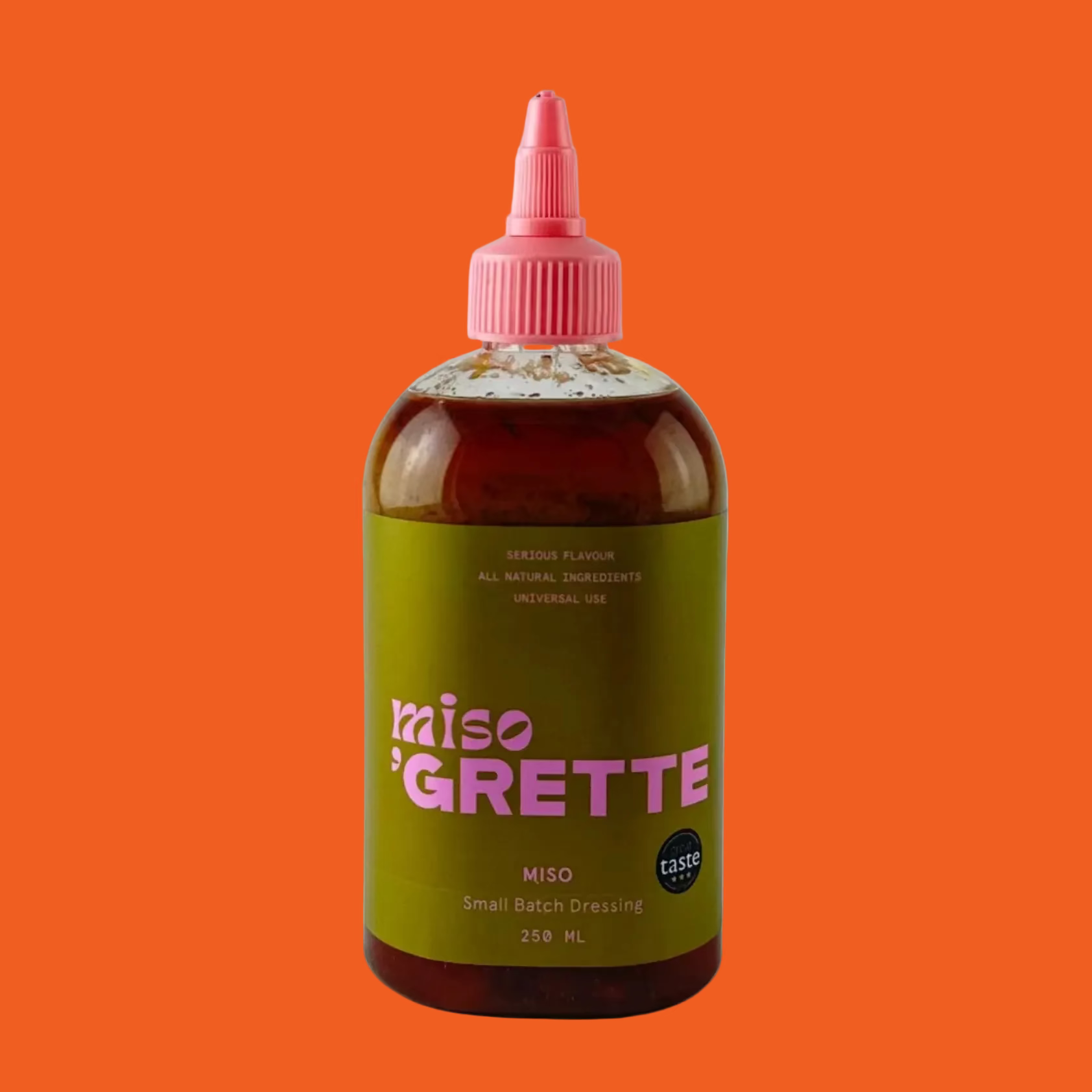 Bottle of miso dressing from Grette with a dark green label on an orange background