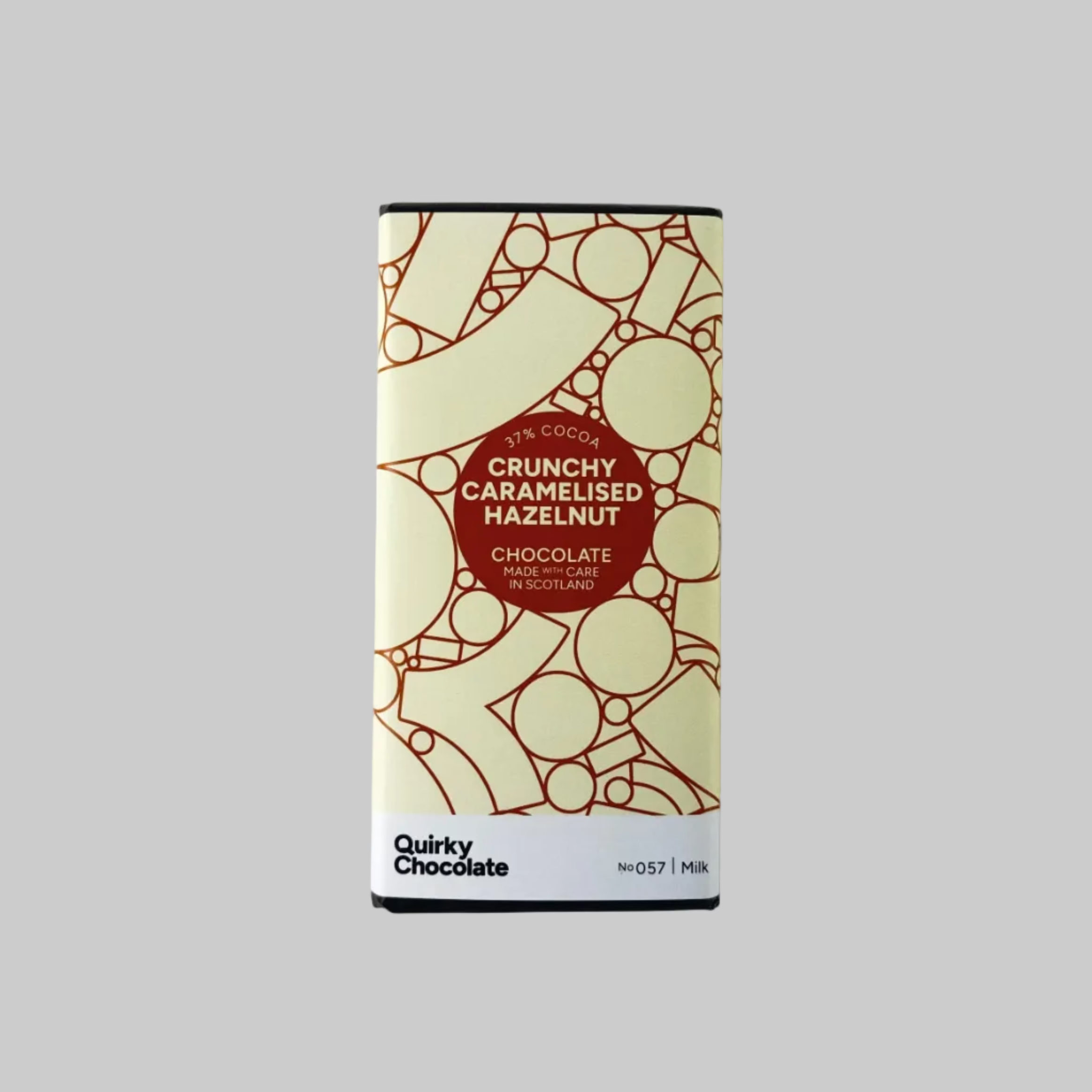 Bar of Quirky Chocolate Crunchy Caramelised Hazelnut Chocolate with geometric label on grey background