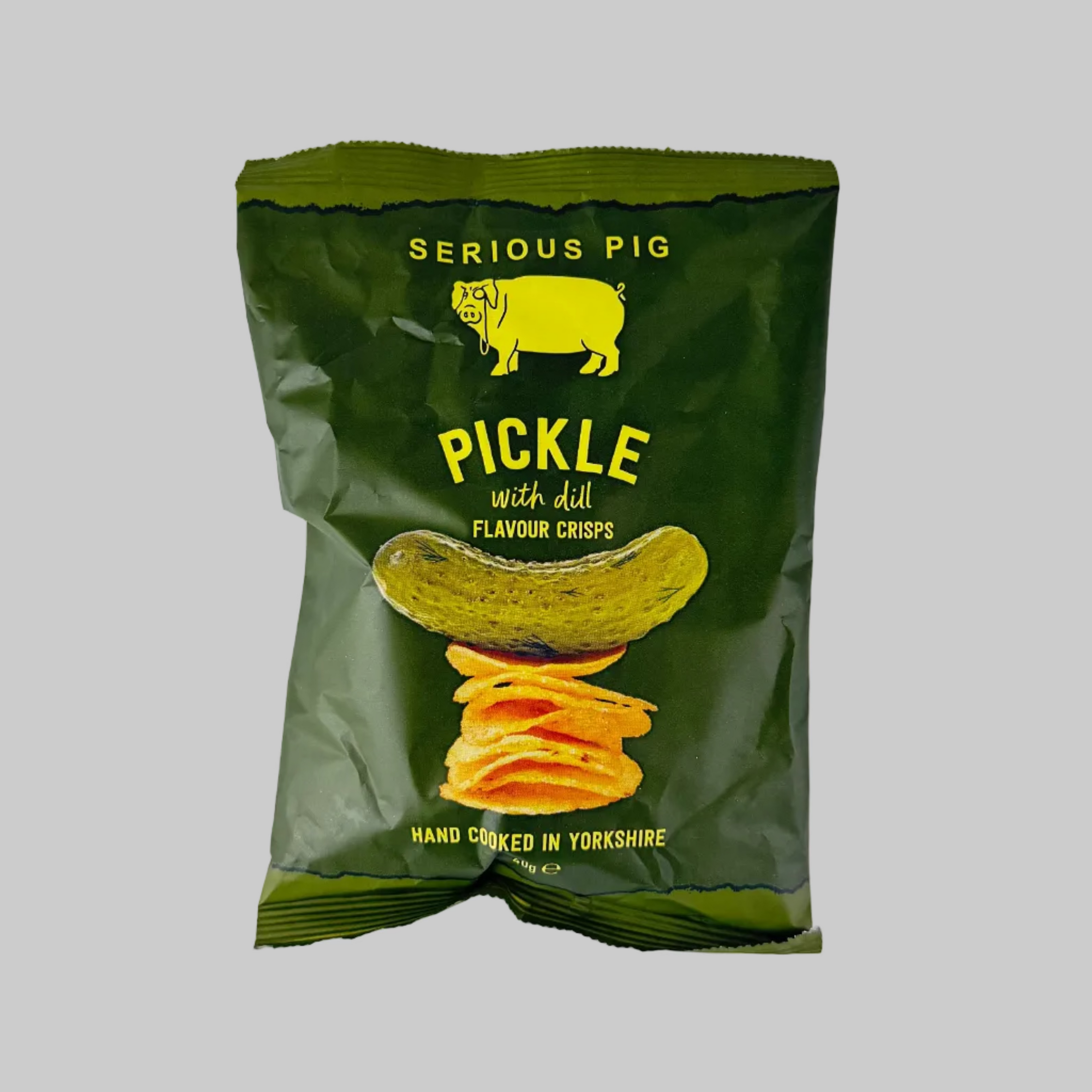 Green packet of 'Serious Pig' pickle-flavored chips on a grey background